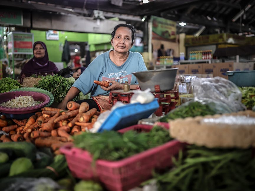 Local woman selling fresh vegetables at an Indonesian market. Vibrant scene with carrots and greens.
